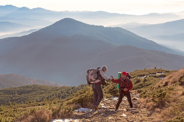 Two Hikers helping each other on Mountain Trail