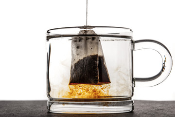 Glass cup with water and tea bag