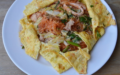 stir fried sukiyaki with seafood wrapped in egg on dish