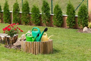 three plastic watering can