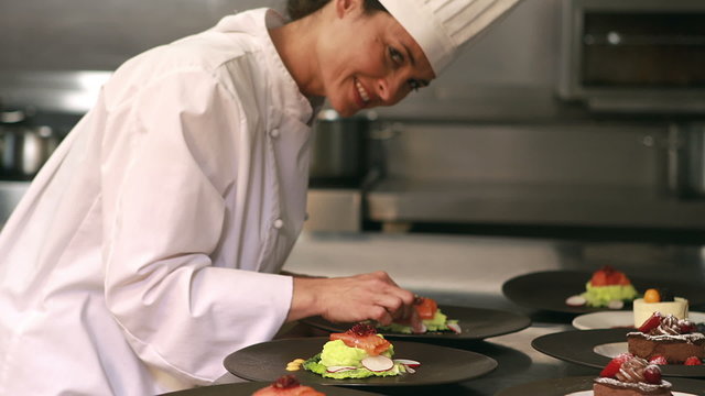 Smiling chef finalizing dishes