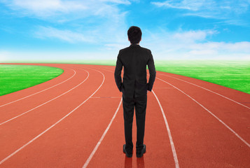 Fototapeta premium businessman standing on running track and looking to goal