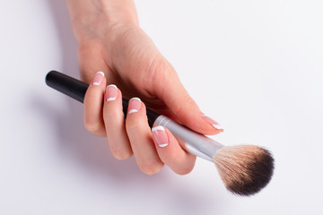 Powder brush in a female hand.