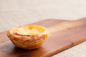 Portuguese egg custard tart, pastéis de nata, served on a wooden board. These delicious bakes are also popular in South East Asia especially in Macau.