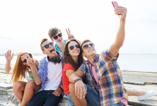 happy friends with smartphone taking selfie