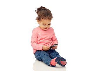 smiling little baby girl playing with smartphone