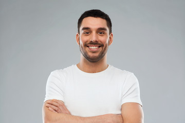 smiling man with crossed arms over gray background