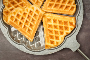 Home made heart shaped waffles served in a traditional cast iron waffle pan.
