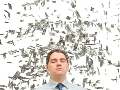 young man dreaming of vacation / a young man in a tie on a white background, standing in the rain of money