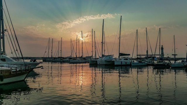 Yachts moored at marina in a row under the sunrise.