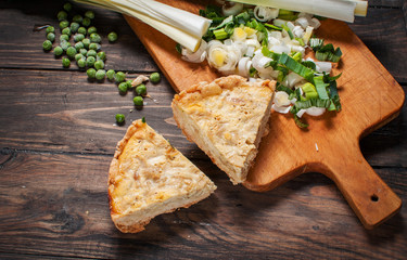 French Quiche Lorraine with ingredients on wood board