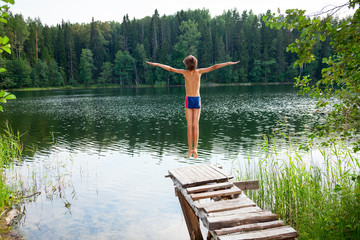 Fototapeta na wymiar Boy jumping into forest lake