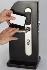 Hand hold key card touch on black electronic pad lock access control