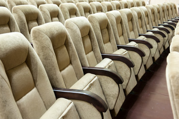 Empty auditorium with beige chairs, theatre or conference hall