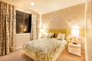 modern bedroom with king size bed illuminated by table lamps
