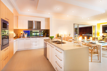 Kitchen and dining area illuminated by ceiling lights and flashi