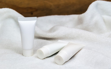 Fototapeta na wymiar various beauty hygiene tubes on towel in spa