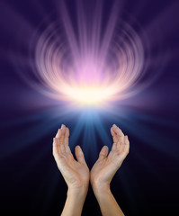 Sacred Healing Energy - female hands reaching up towards a glowing energy manifestation shaped like a lotus flower in pink and yellow with plenty of copy space