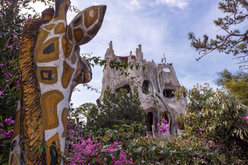 Obraz premium Sculpture of a giraffe in the garden's greenery nearby the Hang Nga guesthouse, popularly known as the Crazy House , Da Lat, Vietnam