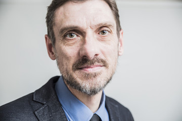 closeup portrait a grown man dressed in a jacket and tie looking at viewer