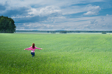 Obraz na płótnie Canvas girl runs on a field of wheat