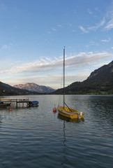 small sailing yacht at sunset on Alpine lake Mondsee, Austria