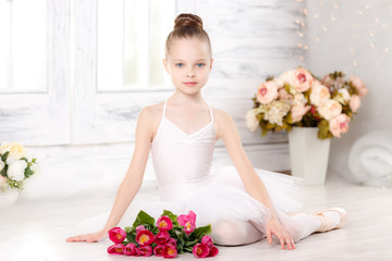 beautiful little ballerina with a bouquet of pink tulips, March 8