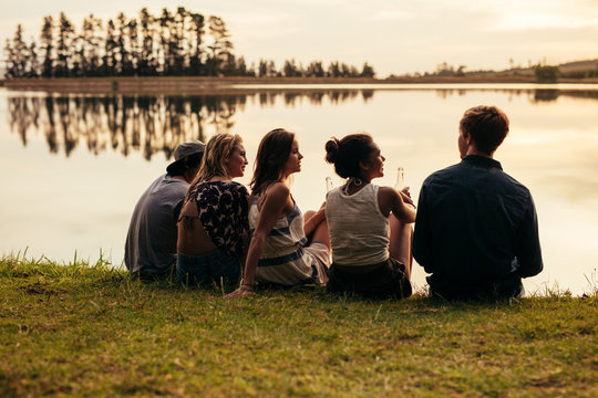 Group Of Young Friends Relaxing By A Lake