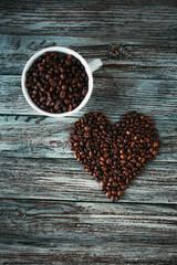 Coffee beans heart and white cup with coffee beans