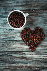 Coffee beans heart and white cup with coffee beans