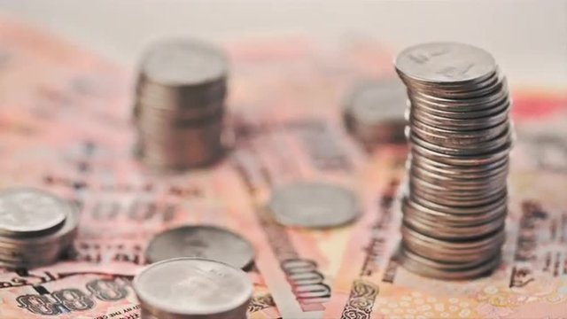 Stack of coins on Indian banknotes