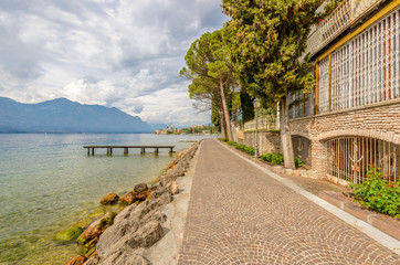 Fototapeta na wymiar Walkpath along beautiful peaceful lake Garda, Italy