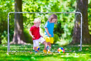 Fotobehang Children playing football outdoors © famveldman