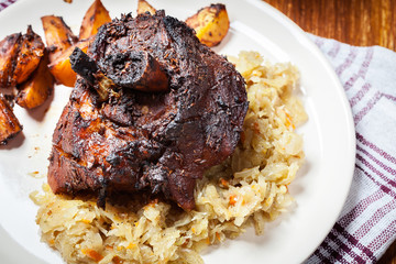 Pork knuckle with fried sauerkraut and baked potatoes