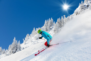 Man skier running downhill on sunny alpine slope