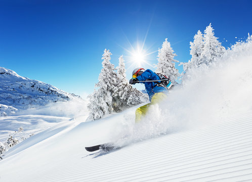 Man skier running downhill on sunny alpine slope
