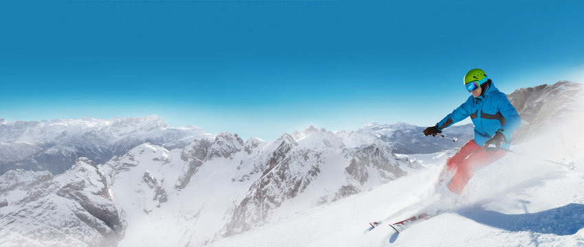 Man skier running downhill on sunny alpine slope