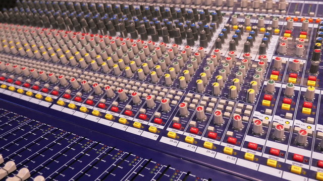 Dolly shot of central console of recording studio