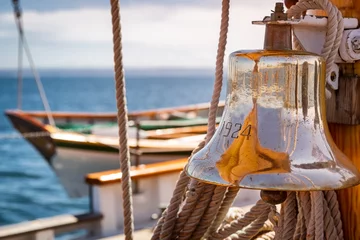 Crédence de cuisine en verre imprimé Naviguer Brass ship bell on a classic big wooden sailboat at sea. Close up