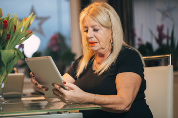 woman 65-70 years old using ipad tablet