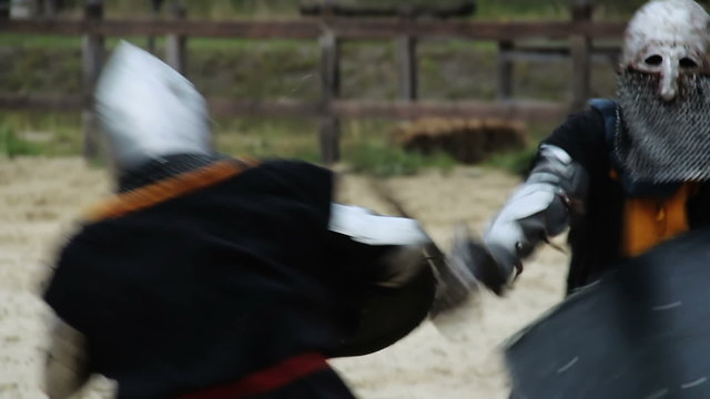Actors wearing medieval armor suits reenacting military skills tournament 