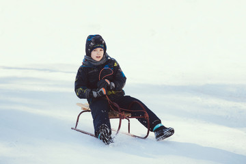 Fototapeta na wymiar Little boy on a sled 