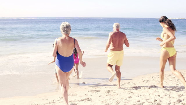 Cute family running in the water on the beach