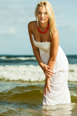 Fototapeta na wymiar Beautiful blonde girl on beach, summertime