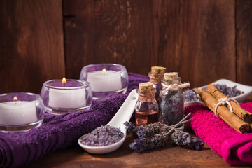 Fototapeta na wymiar Spa candle and lavender bath salts on a wooden background