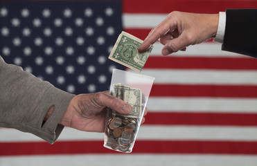 American Gothic Series/suited man's hand placing dollar bill into money-filled plastic cup held by...
