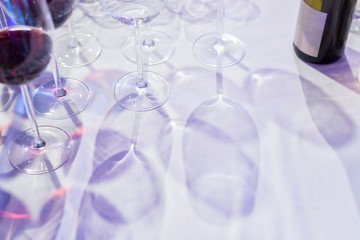 Glasses of wine shadowed on a white tablecloth. Useful to fill text in.
