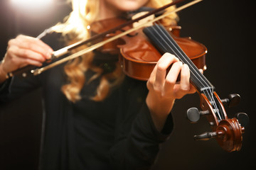 Fototapeta premium Musician plays violin on black background, close up