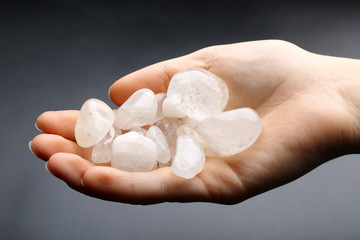 Woman holding semiprecious stones in her hand on dark grey background