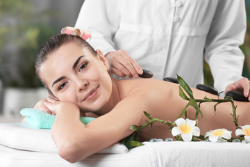 Obraz na płótnie Canvas Woman getting a hot stone massage at spa salon